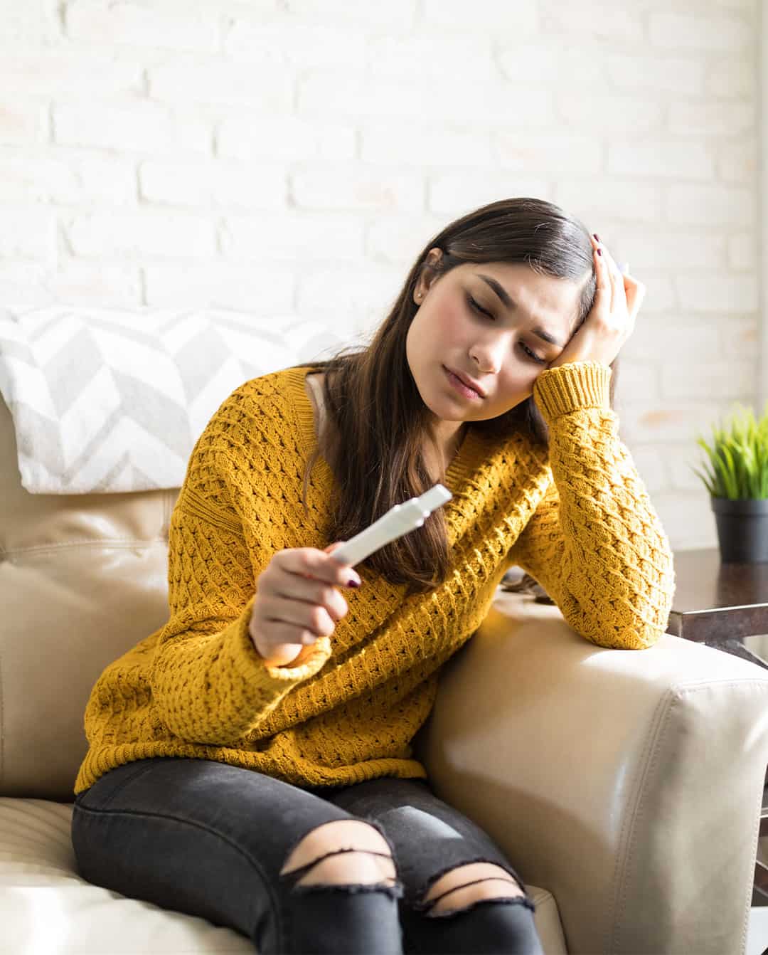 Mujer preocupada con una prueba de embarazo en sus manos